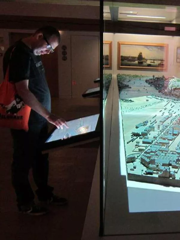 Un visiteur qui utilise un borne tactile dans les musées digitalisés